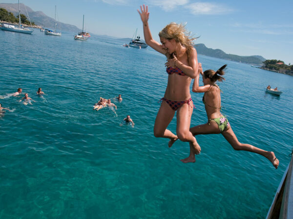 Summer sailing friends jumping ocean