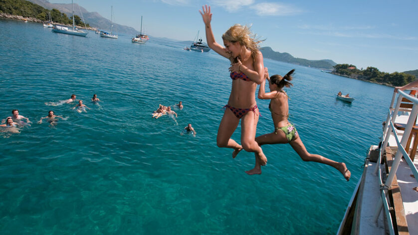 Summer sailing friends jumping ocean